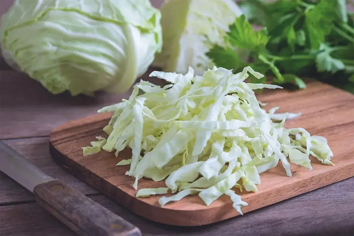 Cavolo cappuccio affettato su tagliere, pronto per gustose ricette.