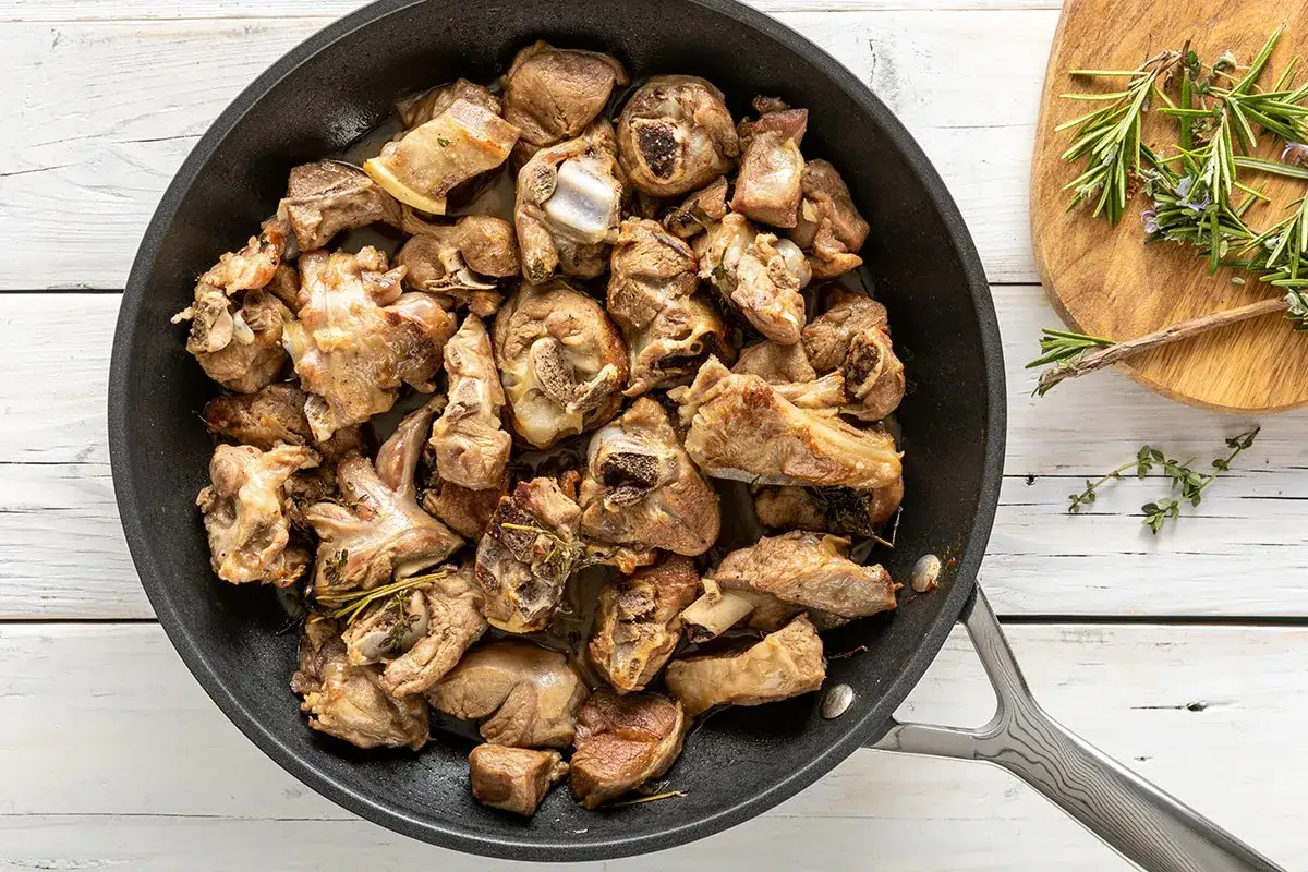 Succulento agnello in padella, cotto a puntino con erbe aromatiche. Un piatto che profuma di tradizione e sapori autentici.