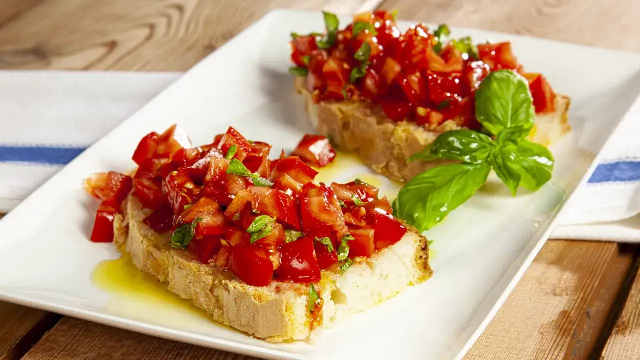 Due fette di pane tostato condite con pomodori freschi a cubetti, basilico e olio d'oliva, un classico della panzanella romana.