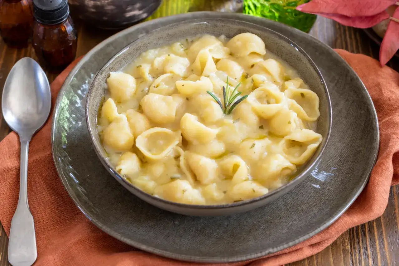 Un piatto fumante di pasta e patate veloce, cremoso e confortante, guarnito con rosmarino.