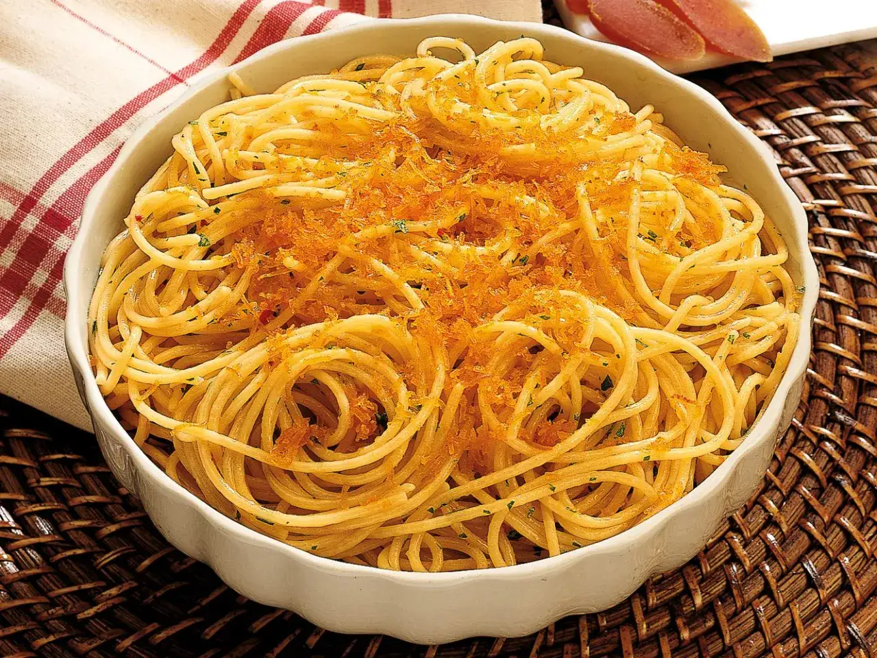 Spaghetti alla bottarga, un piatto saporito con pasta dorata e un topping di uova di pesce essiccate.