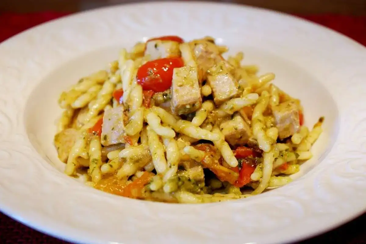 Pasta alla carlofortina con tonno, pomodorini e pesto, un piatto saporito e colorato.