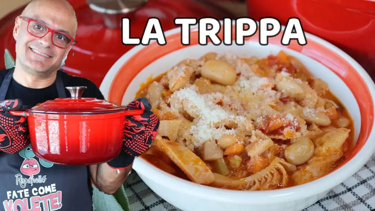 Un uomo sorridente con occhiali rossi tiene una pentola rossa, accanto a una ciotola di trippa alla milanese fumante, cosparsa di parmigiano.