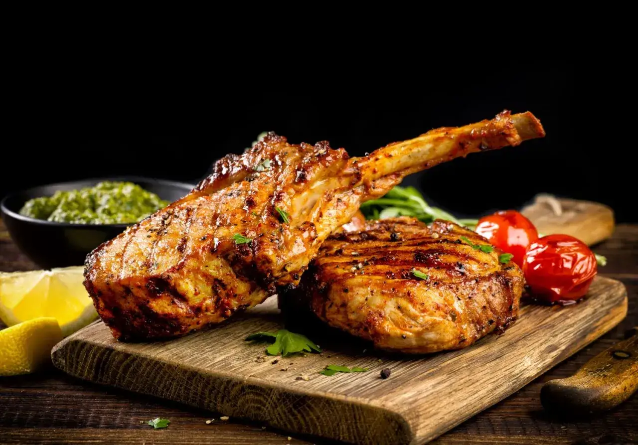 Due succulenti tomahawk alla griglia, con pomodorini e limone, pronti per essere gustati.