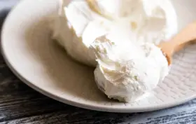 Crema bianca e soffice su un piatto, pronta per essere usata come ingredienti per mascarpone.