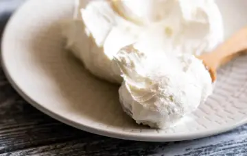 Crema bianca e soffice su un piatto, pronta per essere usata come ingredienti per mascarpone.